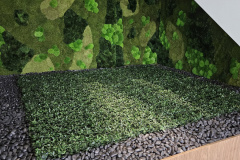 Artificial ground cover framed with black river rock add interest under a staircase in this Brampton office