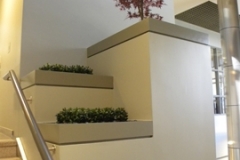 Artificial Boxwood and Japanese Red Maple surrounded by river rock in stairway planters